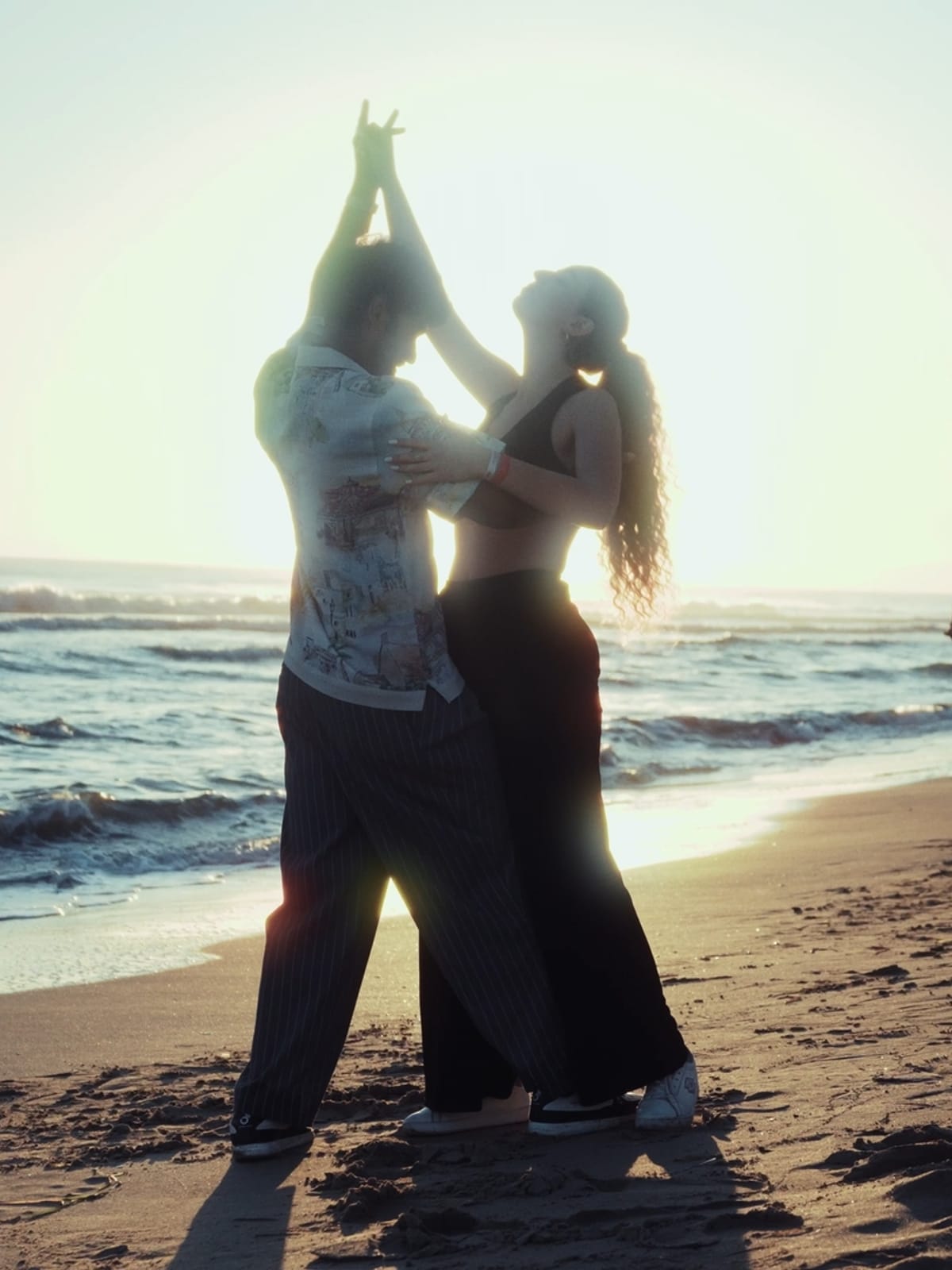A couple dancing on the beach at sunset